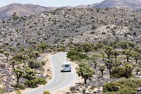 C Class RV driving a desert road toward mountains